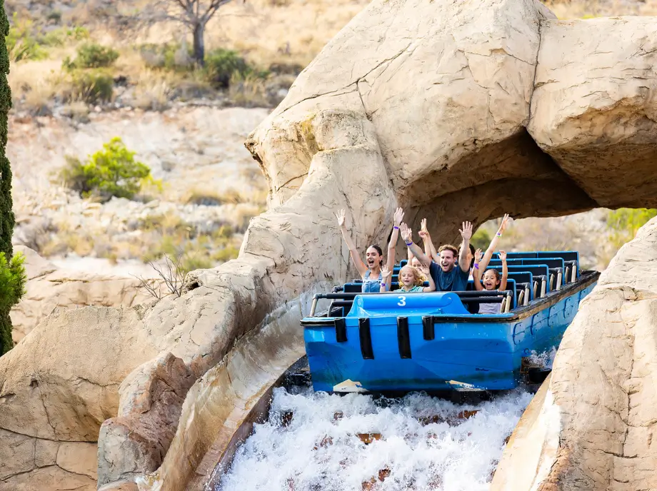 Attraction aquatique à Terra Mitica à Benidorm avec un bateau bleu descendant entre les rochers.