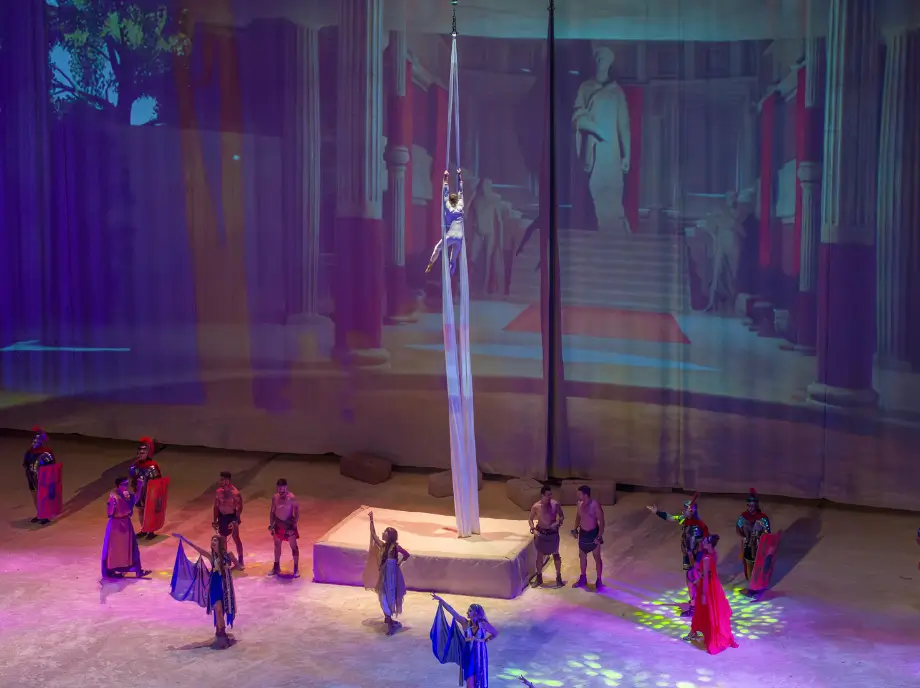 Spectacle nocturne à Terra Mitica Benidorm avec acrobates, lumières et scène illuminée.