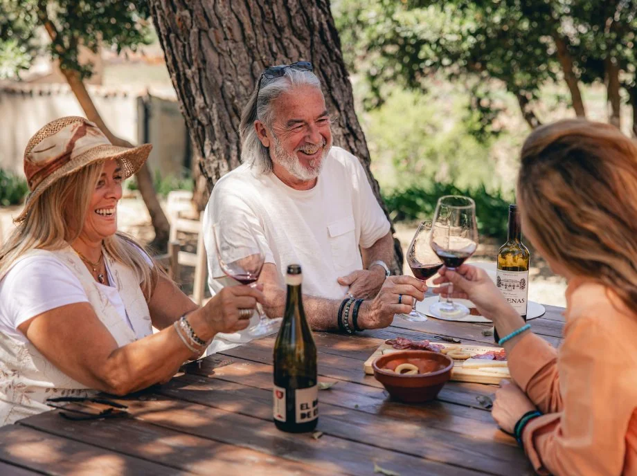 Familia disfrutando de una cata de vinos con tabla de embutidos al aire libre en Utiel-Requena.