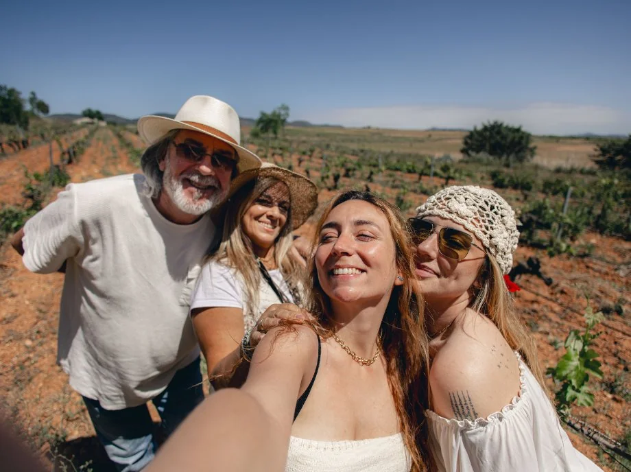 Grupo de amigos haciéndose un selfie en los viñedos de Requena bajo el sol.