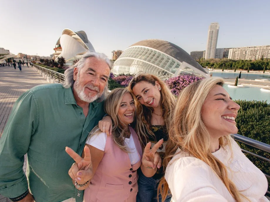 Familia haciéndose un selfie con el Hemisfèric y el Palau de les Arts al fondo en Valencia.
